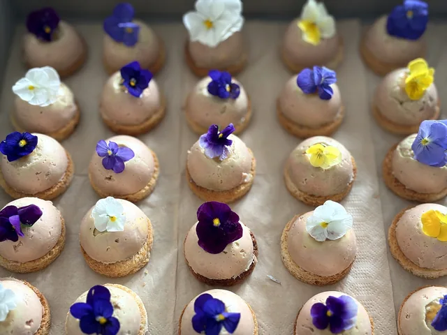 Petits dômes sur une base ronde, décorés de fleurs violettes, blanches et jaunes.